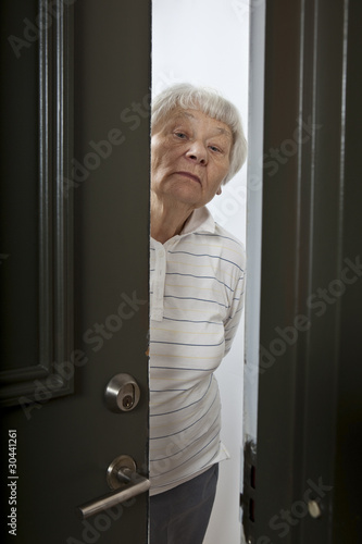 Annoyed senior woman answering front door