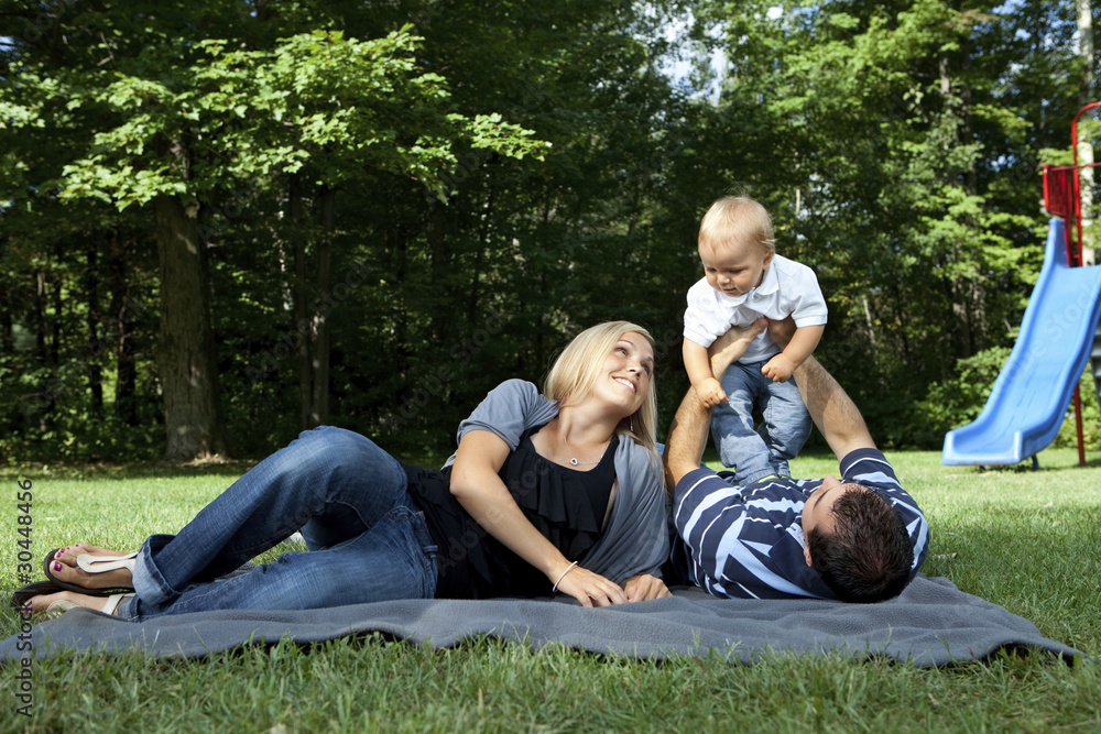 Fototapeta premium Young family playing at a park