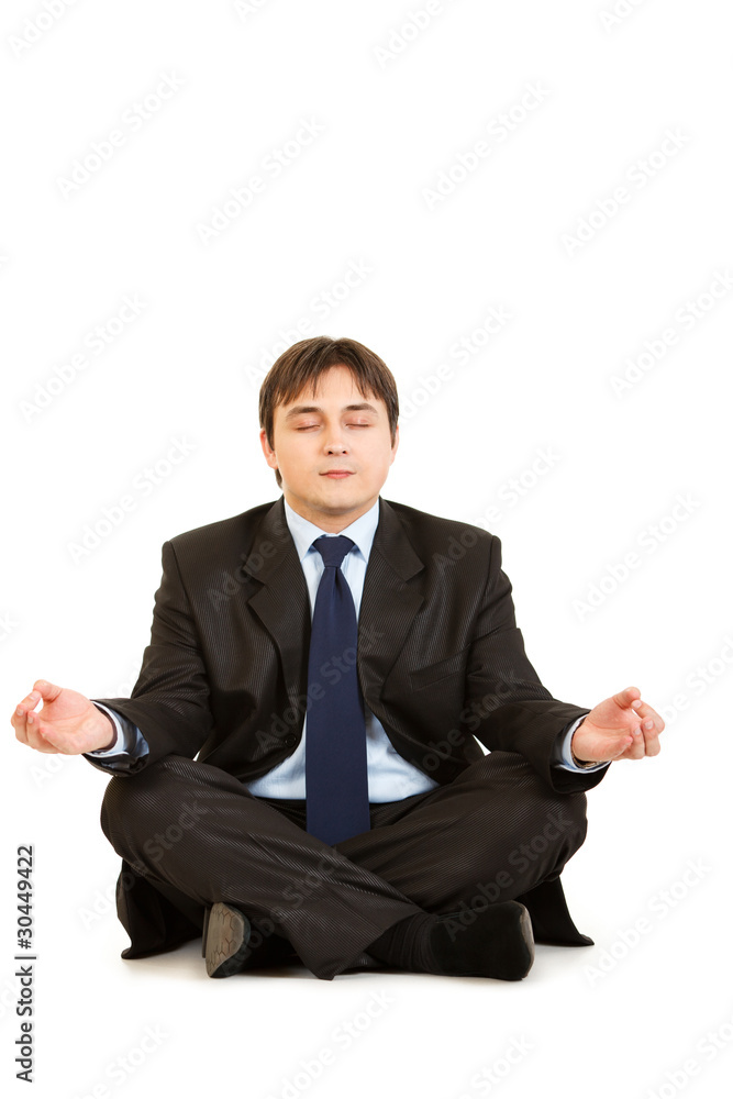 Meditating modern businessman sitting on floor Meditating modern businessman sitting on floor
