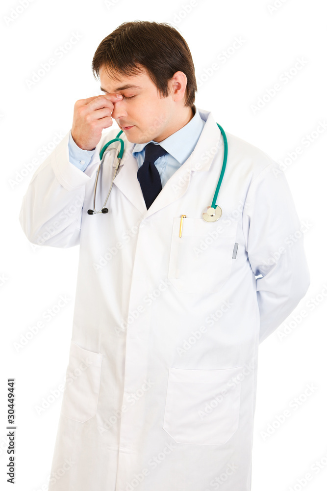 Stressed medical doctor holding fingers at noseband Stressed medical doctor holding fingers at noseband