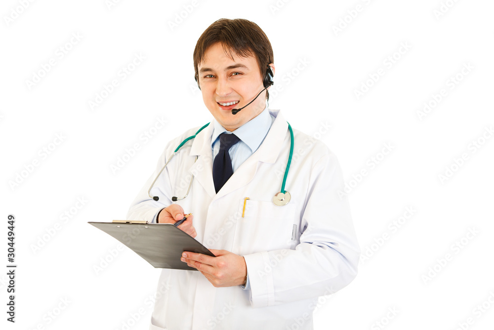 Smiling medical doctor with headset holding clipboard in hand Smiling medical doctor with headset holding clipboard in hand