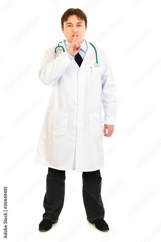 Serious medical doctor with finger at mouth. Shh gesture. Serious medical doctor with finger at mouth. Shh gesture.
