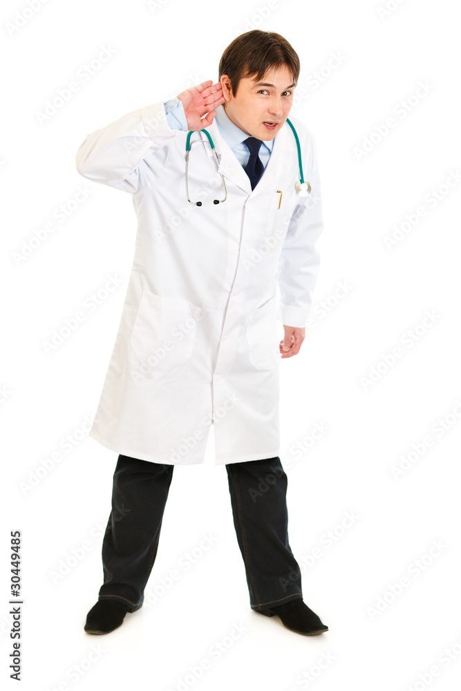Concentrated  medical doctor holding hand at ear and listening