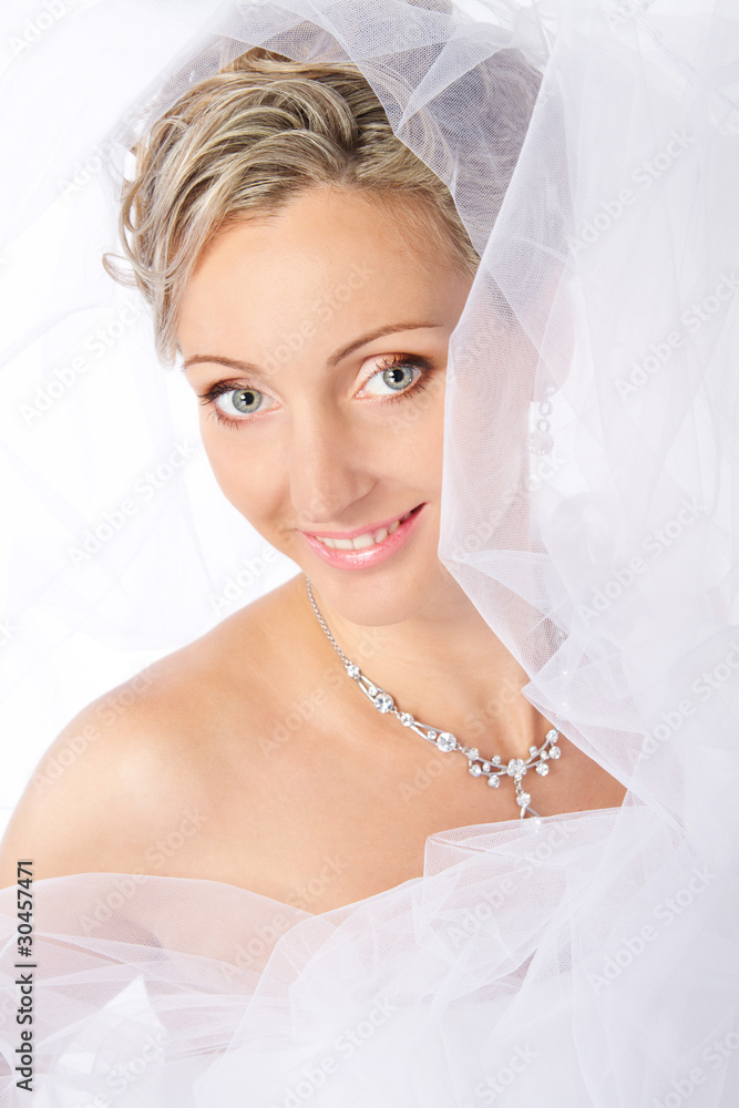 Bride in white veil smiling and looking at camera. Bride in white veil smiling and looking at camera.