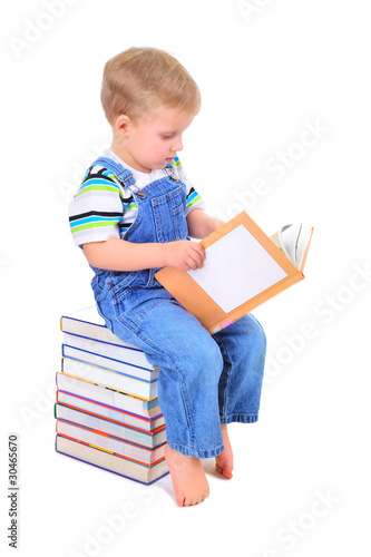 Cute little boy is reading a book