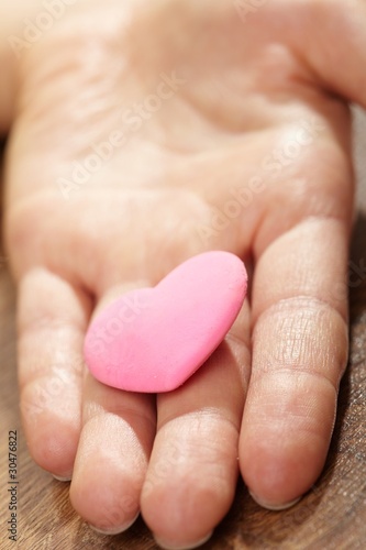 Woman holding pink heart in the hand