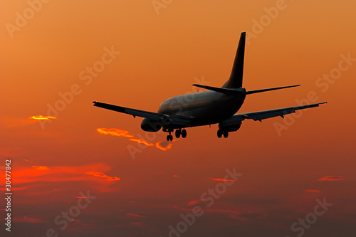 Jet plane landing in sunset