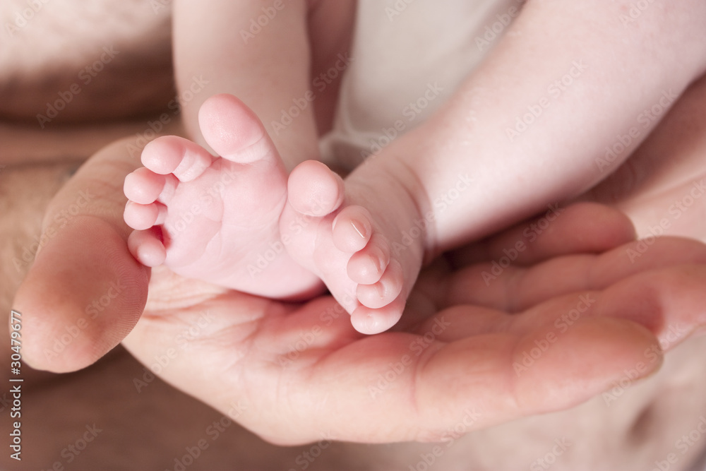 new born baby childs feet in fathers hands new born baby childs feet in fathers hands