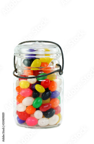 Colorful Jelly Beans fill a vintage mason jar.  Isolated on white with copy space.