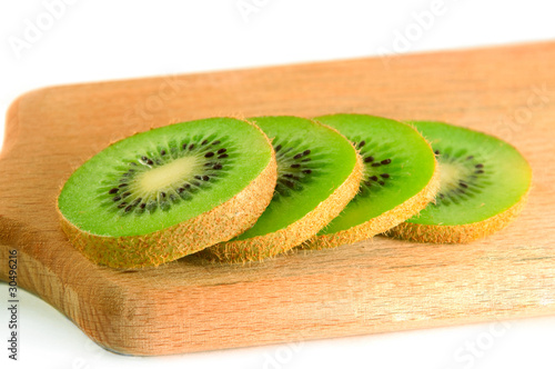 sliced kiwi on the board isolated over white
