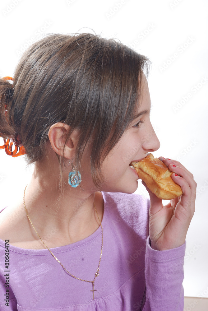 A  young girl eating a bun