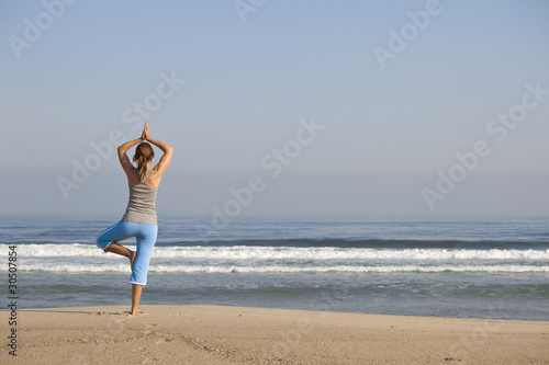 Beautiful young woman with arms open  relaxing on the beach