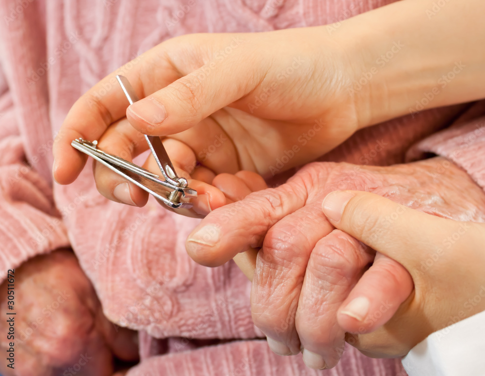 Helping senior woman cutting her nails Helping senior woman cutting her nails