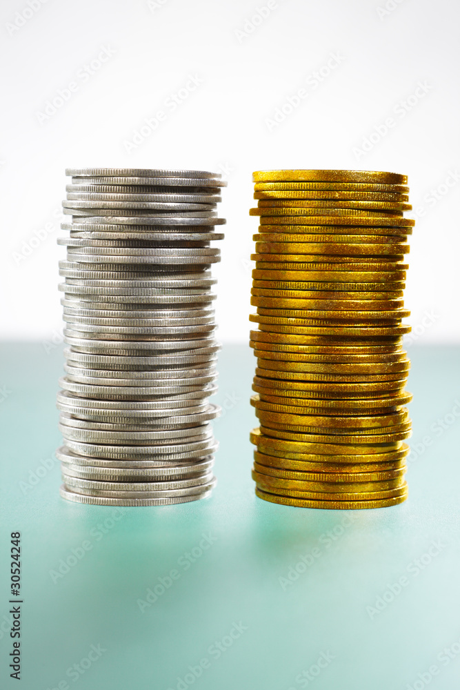 Two stack of silver and gold coins Two stack of silver and gold coins