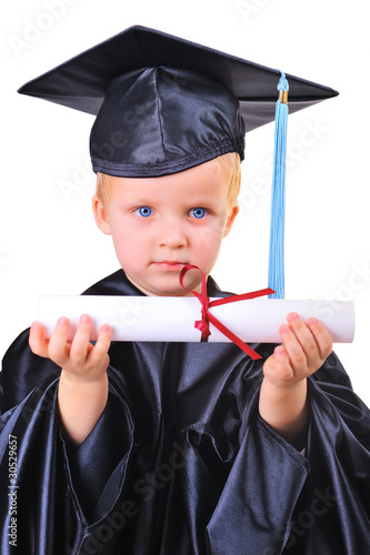 Sirious little boy in graduation dress receiving his first diplo photo