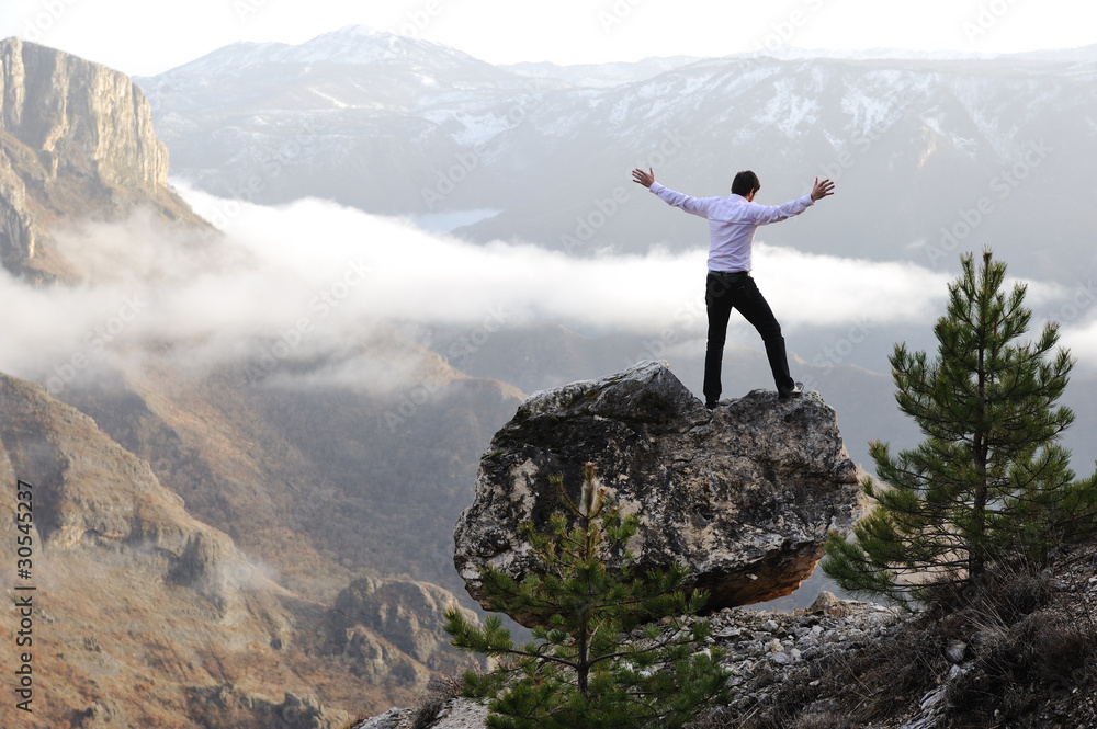 Man on top of mountain with open arms. Conceptual design Man on top of mountain with open arms. Conceptual design