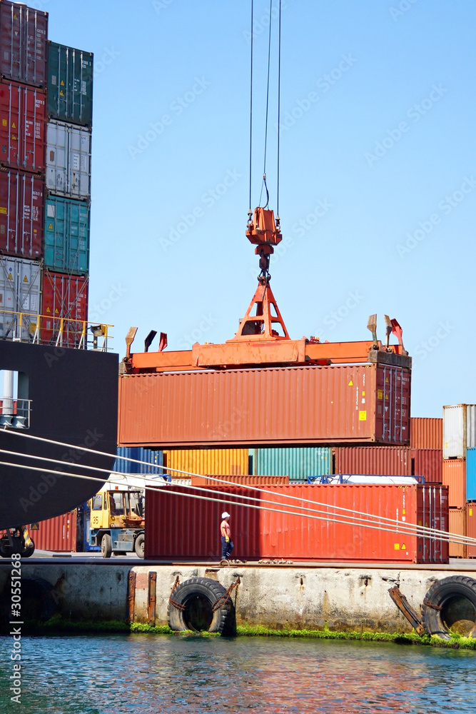 Naklejka premium Freight container hanging on crane at sea port