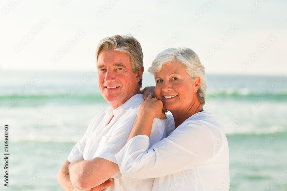Woman hugging her husband at the beach Woman hugging her husband at the beach