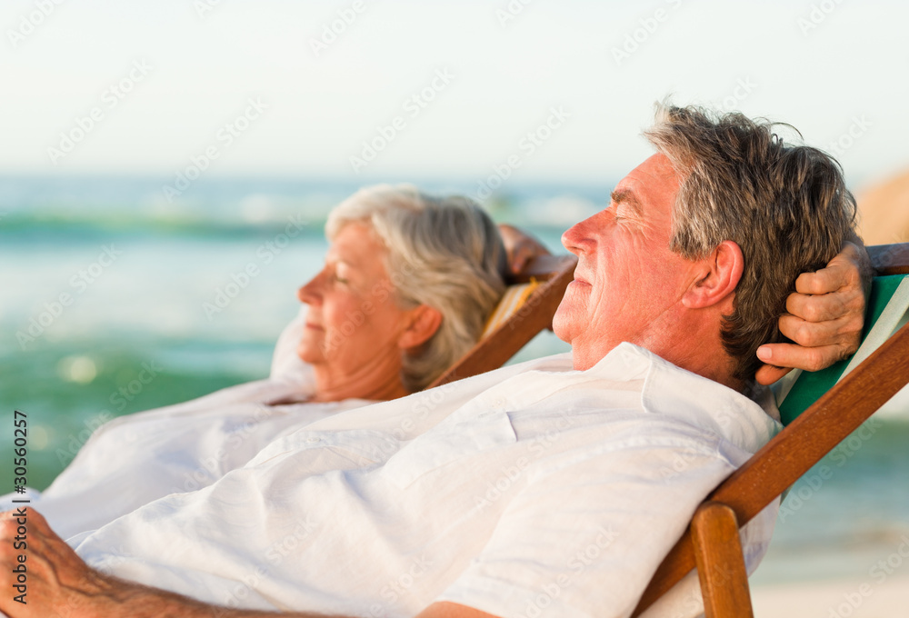 Elderly couple relaxing in their deck chairs Elderly couple relaxing in their deck chairs