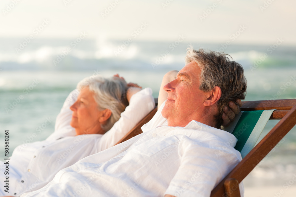 Elderly couple relaxing in their deck chairs Elderly couple relaxing in their deck chairs