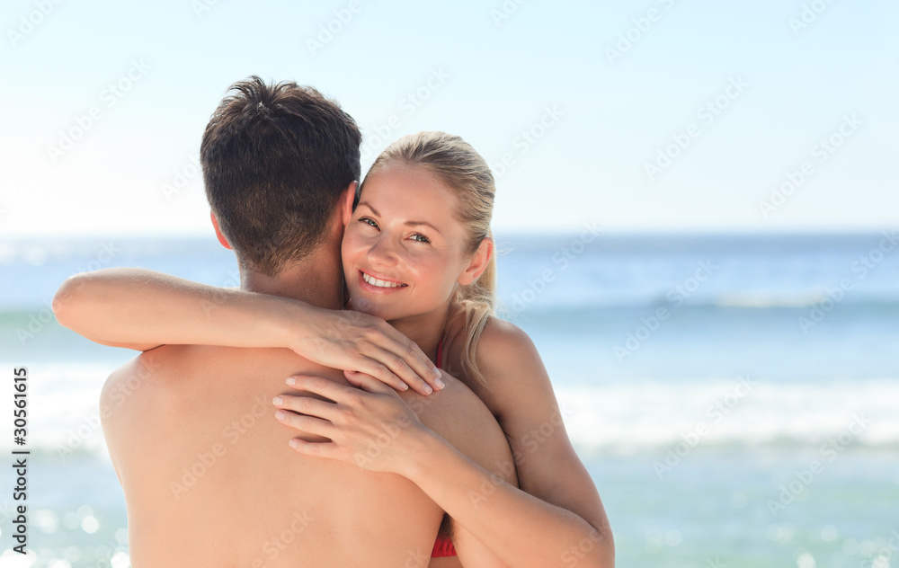Woman hugging her boyfriend at the beach Woman hugging her boyfriend at the beach