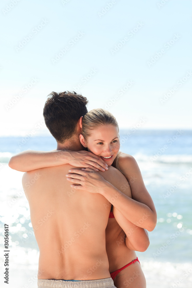Woman hugging her boyfriend at the beach Woman hugging her boyfriend at the beach