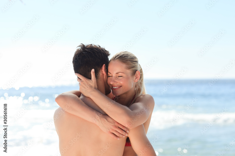Woman hugging her boyfriend at the beach Woman hugging her boyfriend at the beach