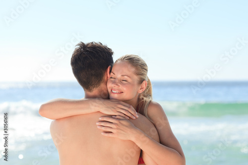Woman hugging her boyfriend at the beach © WavebreakMediaMicro