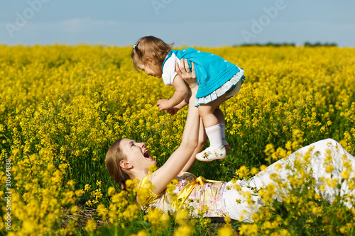 mother with baby on yellow field