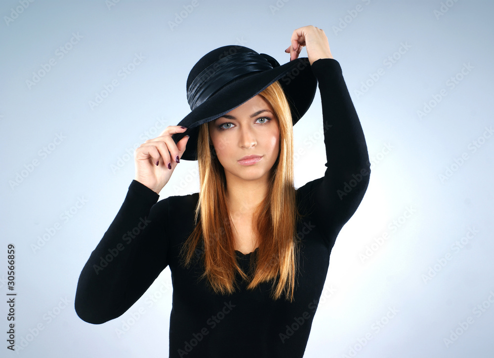 Fashion shoot of a young Caucasian woman in a black hat Fashion shoot of a young Caucasian woman in a black hat