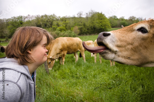 Jeune fille trisomique regardant une vache