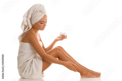 Woman applying body lotion