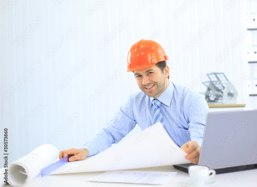 Architect looking working in office at desk. Architect looking working in office at desk.