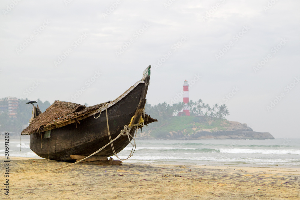 Traditional wooden fishing boat on Kovalam beach, Kerala, India