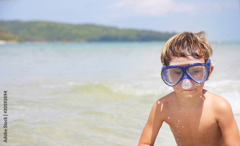 young boy in diving mask on sea background