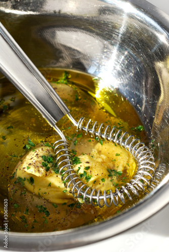 Vinaigrette ingredients in a metal bowl with a whisk