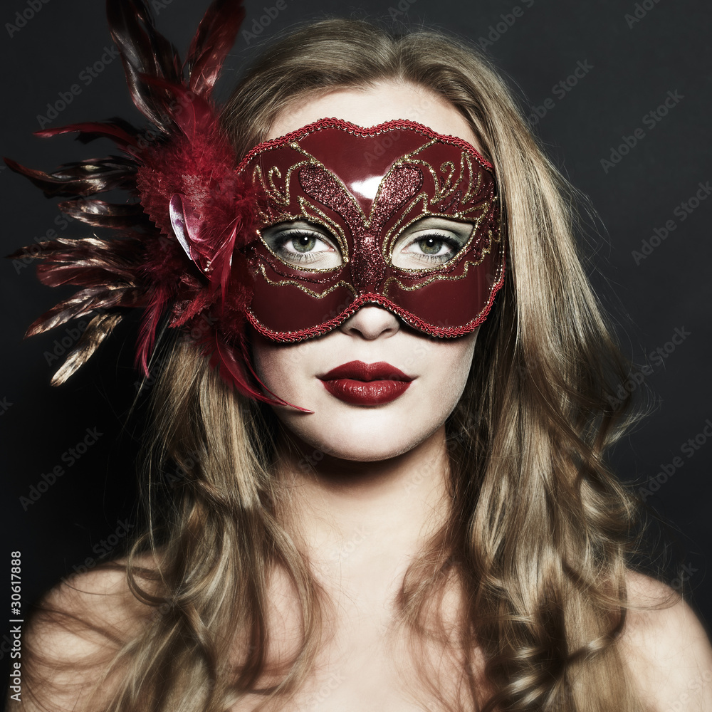 Beautiful young woman in a red mysterious venetian mask Beautiful young woman in a red mysterious venetian mask
