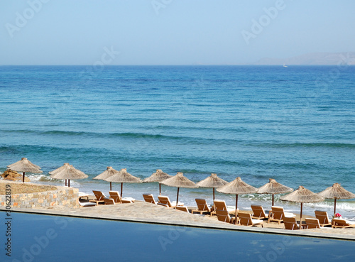 Fototapeta Naklejka Na Ścianę i Meble -  Sunbeds at the beach of luxury hotel, Crete, Greece