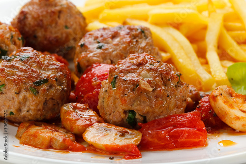 Roasted meatballs, French fries and vegetables