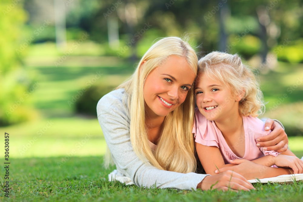 Mother with her daughter lying down in the park Mother with her daughter lying down in the park