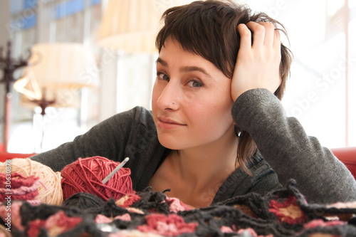 Portrait of a young beautiful girl with knitting