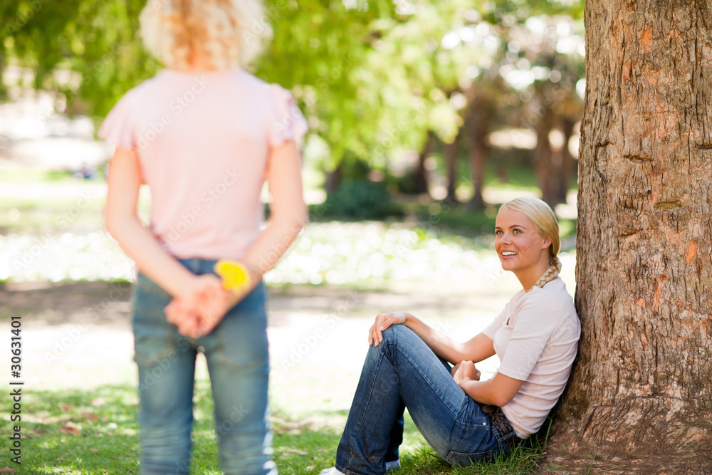 Fototapeta premium Daughter offering a flower to her mother