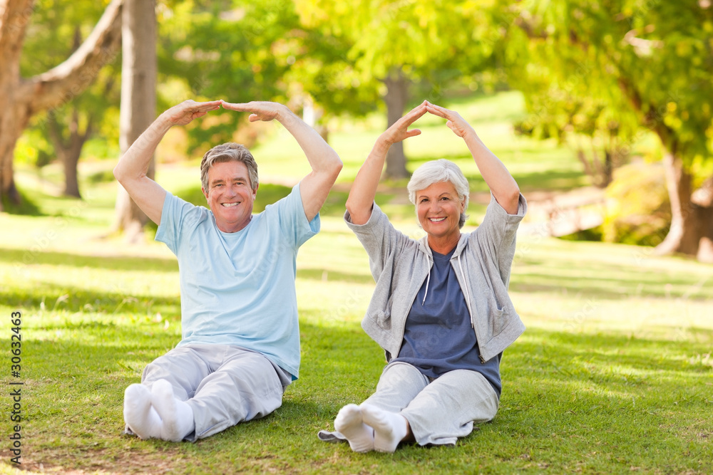Fototapeta premium Elderly couple doing their stretches in the park