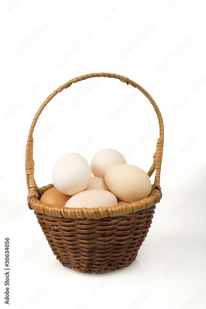 Eggs in a small basket on a white background Eggs in a small basket on a white background