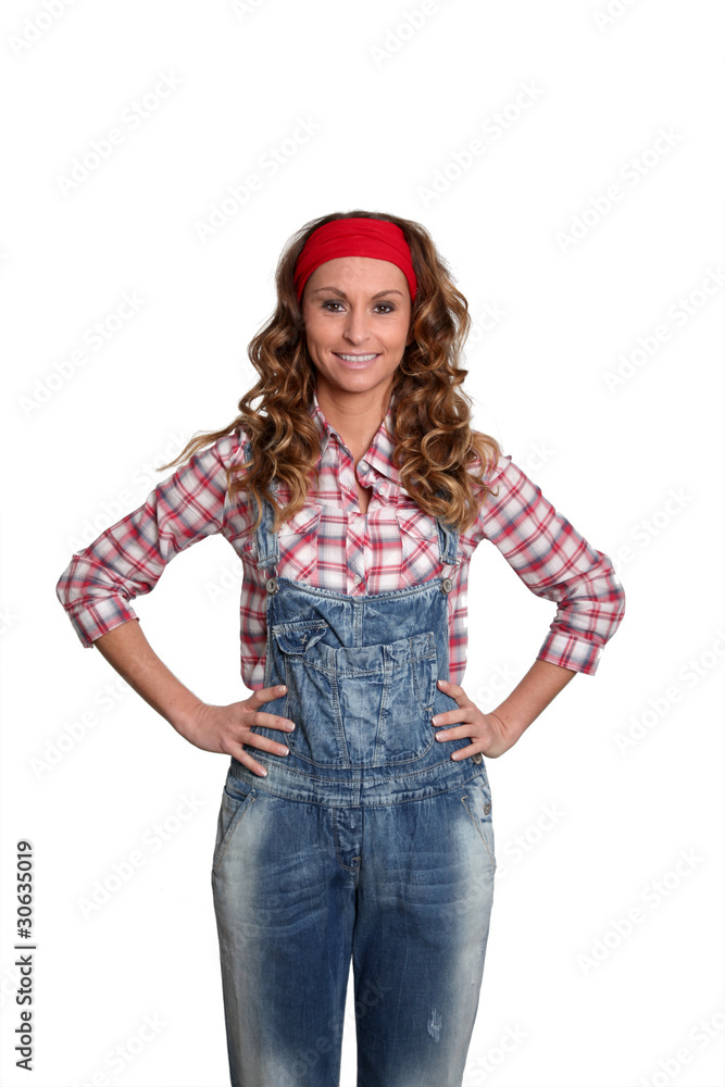 Woman with blue jeans overalls standing on white background Woman with blue jeans overalls standing on white background