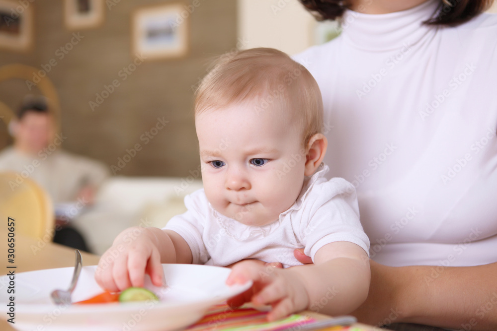 a young mother feeding her baby at home a young mother feeding her baby at home