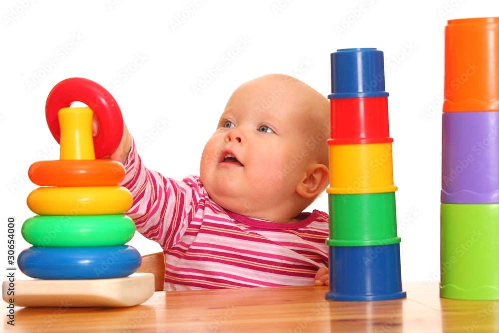 Kleines Mädchen spielt mit ihrer Spielzeugpyramide Kleines Mädchen spielt mit ihrer Spielzeugpyramide