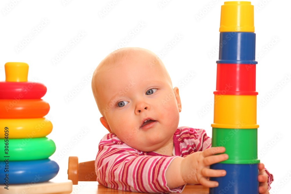 Kleines Mädchen spielt mit einer Spielzeugpyramide Kleines Mädchen spielt mit einer Spielzeugpyramide