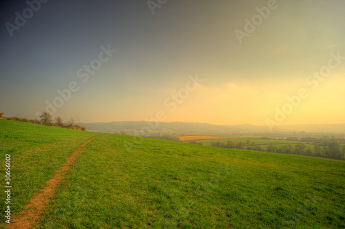 Rolling hill landscape with a pathway and cloudy sky