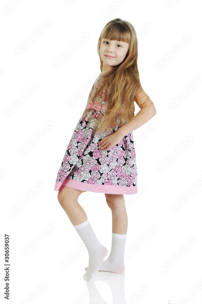 Naklejka premium Charming little girl standing in a model pose. Isolated on the w